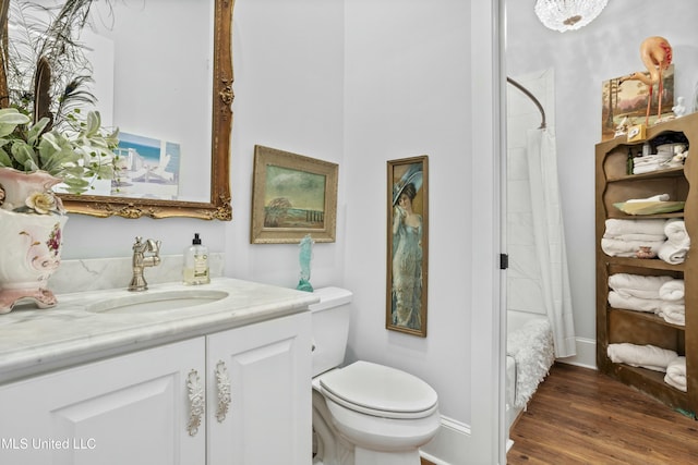 bathroom featuring toilet, vanity, wood finished floors, a shower with curtain, and baseboards