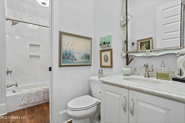 bathroom featuring wood finished floors, bathtub / shower combination, vanity, and toilet