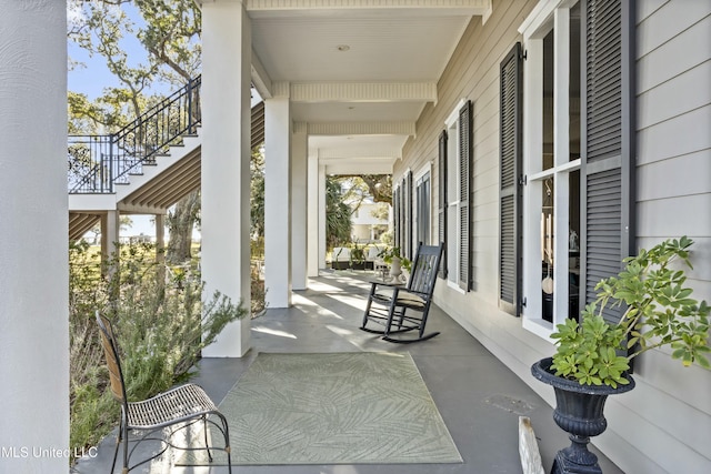 view of patio featuring a porch and stairway