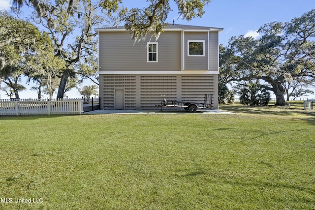 back of house featuring a lawn and fence