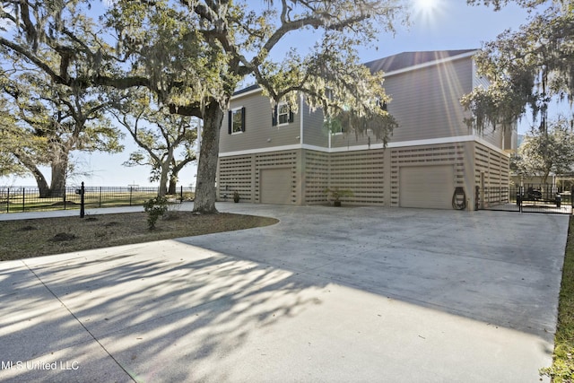 view of front of house with driveway, a garage, and fence