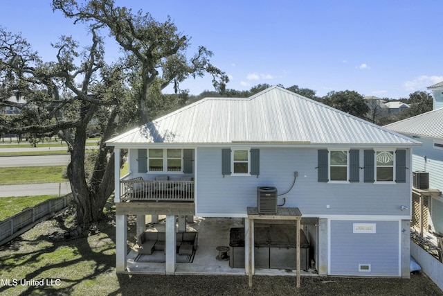 back of property with metal roof, a patio, central AC, and fence