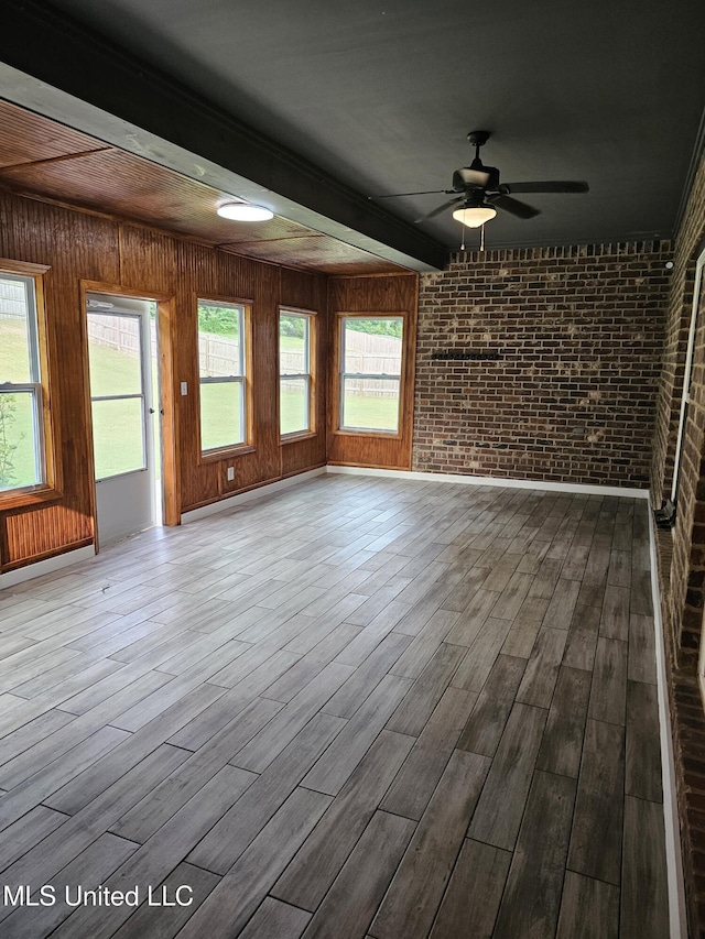 3545 Bailey Ln, Southaven, MS 38672 - unfurnished living room with brick wall, wood finished floors, ceiling fan, and beamed ceiling