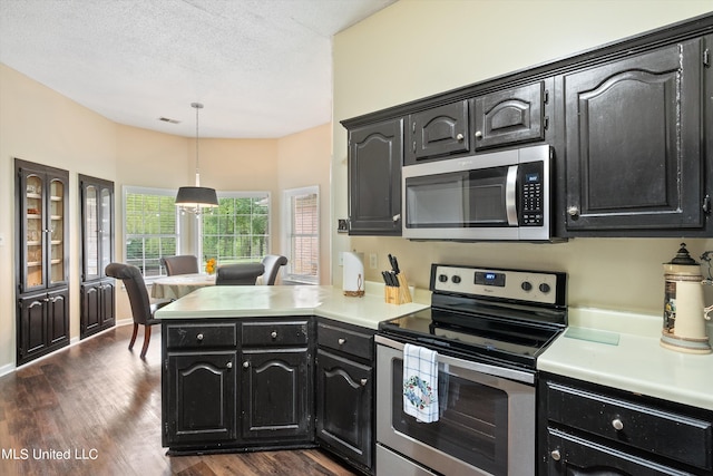 kitchen featuring kitchen peninsula, hanging light fixtures, dark hardwood / wood-style flooring, appliances with stainless steel finishes, and a textured ceiling