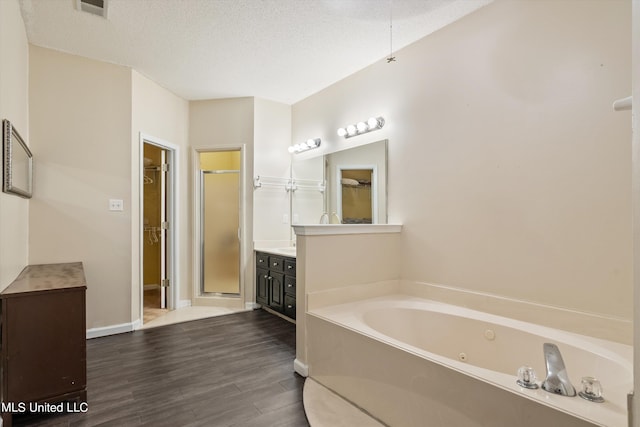 bathroom with vanity, hardwood / wood-style floors, separate shower and tub, and a textured ceiling