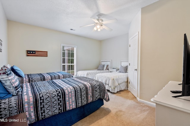 carpeted bedroom featuring a textured ceiling and ceiling fan