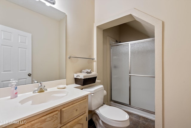 bathroom with toilet, tile patterned flooring, vanity, and a shower with door