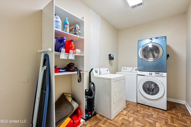 laundry area featuring parquet floors and stacked washer and dryer