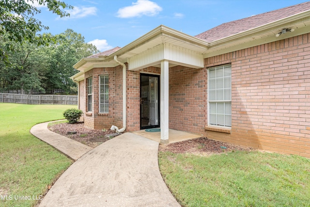 doorway to property with a lawn