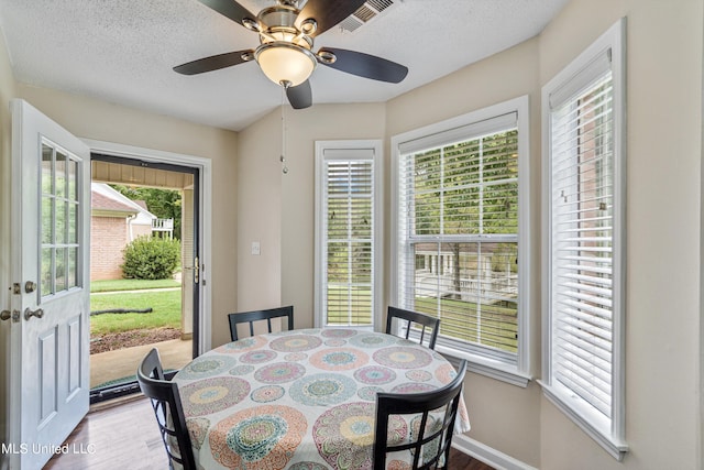 dining space with a textured ceiling, hardwood / wood-style flooring, and ceiling fan