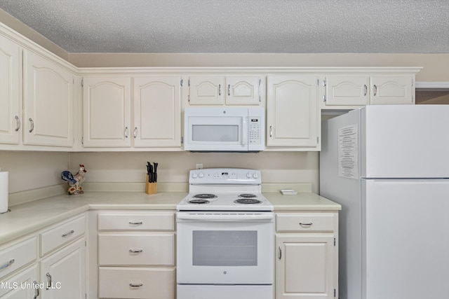 kitchen featuring white appliances, a textured ceiling, and white cabinets