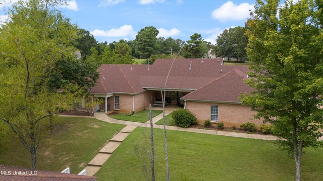 rear view of property featuring a patio area and a lawn