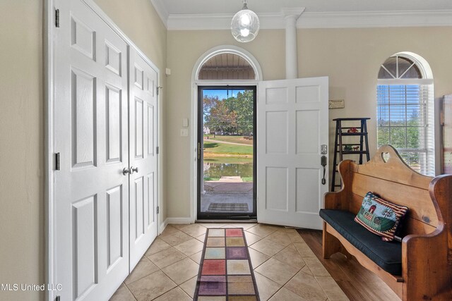 tiled entrance foyer with a wealth of natural light and crown molding