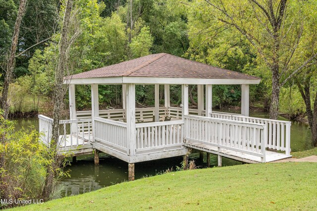 view of dock with a water view, a gazebo, and a yard