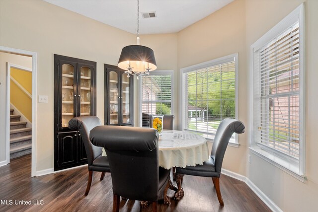 dining room with dark wood-type flooring and a notable chandelier