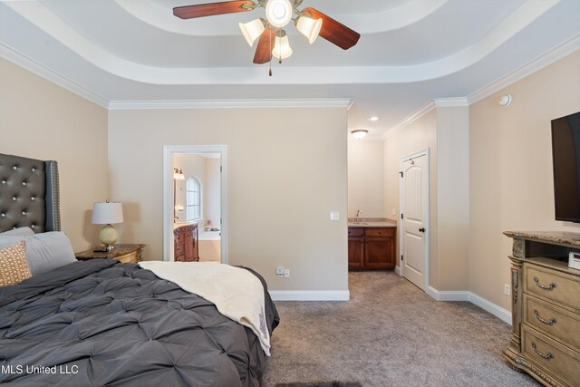 carpeted bedroom with crown molding, a raised ceiling, ceiling fan, and ensuite bathroom