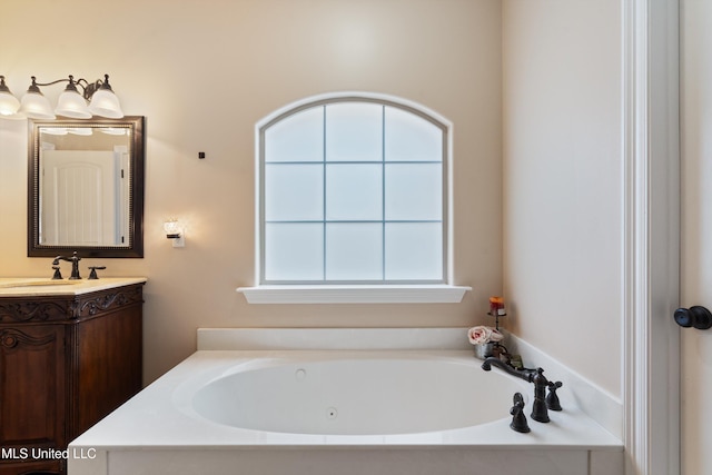 bathroom with a washtub, vanity, and a healthy amount of sunlight