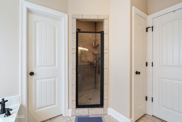 bathroom with tile patterned floors and a shower with door