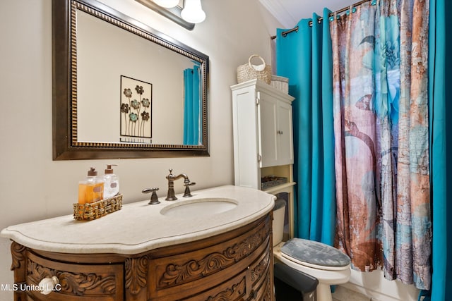 bathroom with toilet, vanity, and crown molding