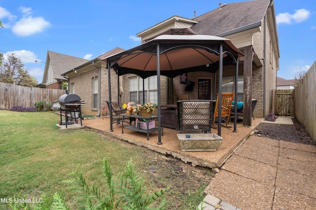 back of property featuring a patio, a yard, and a gazebo