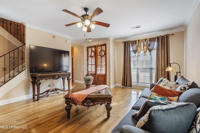 living room with ornamental molding, ceiling fan, and light hardwood / wood-style flooring