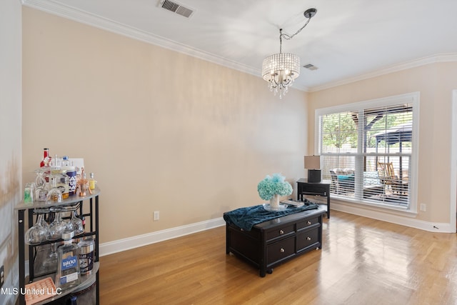 living area featuring a chandelier, light hardwood / wood-style flooring, and ornamental molding