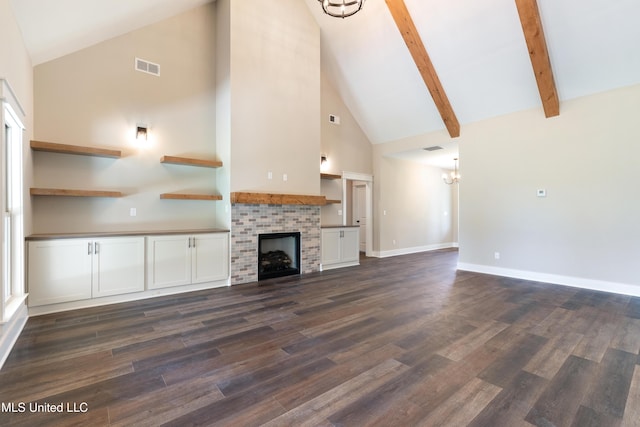 13721 Pebble Ridge Dr, Byhalia, MS 38611 - unfurnished living room with high vaulted ceiling, a chandelier, dark wood-style floors, a brick fireplace, and baseboards