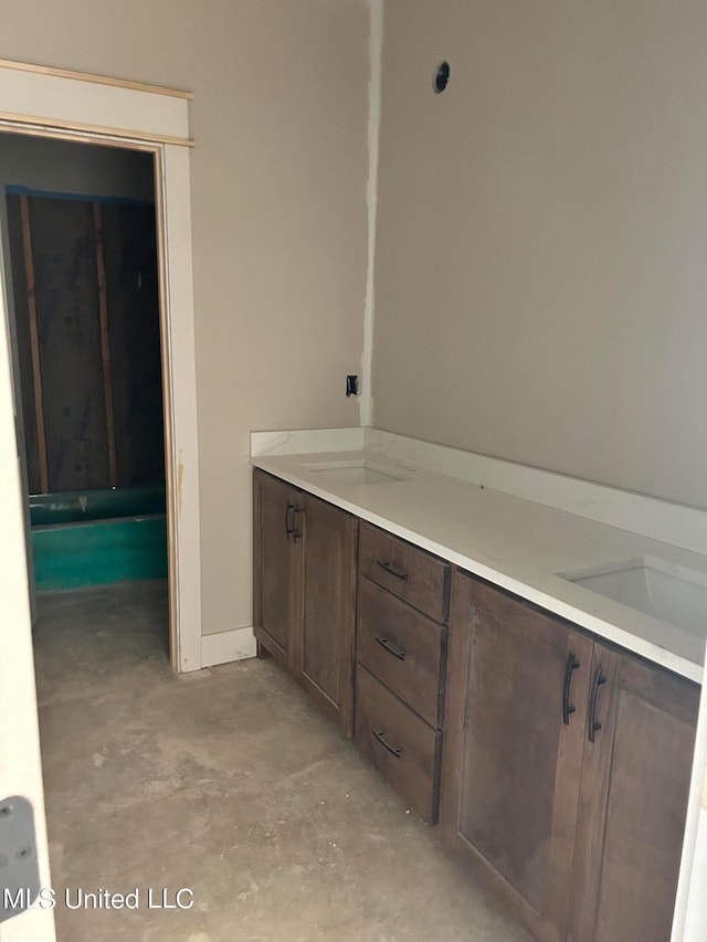 bathroom with vanity and unfinished concrete flooring