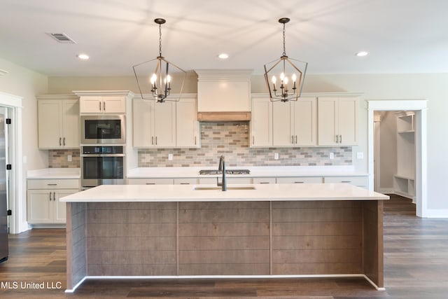 13721 Pebble Ridge Dr, Byhalia, MS 38611 - kitchen with appliances with stainless steel finishes, a chandelier, light countertops, a center island with sink, and recessed lighting