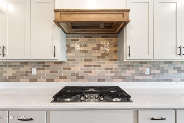 13721 Pebble Ridge Dr, Byhalia, MS 38611 - kitchen with stainless steel gas cooktop, white cabinetry, tasteful backsplash, and light stone countertops