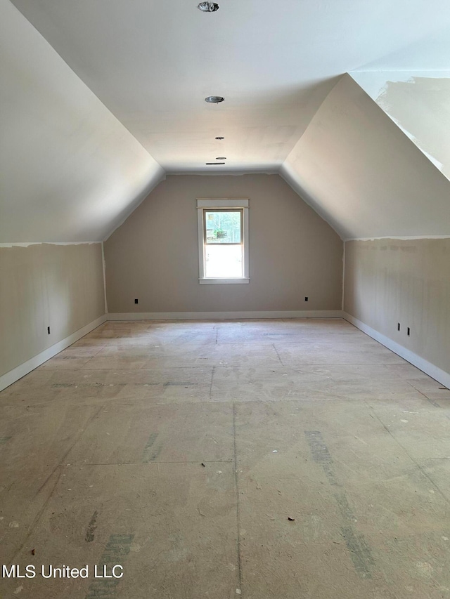 bonus room featuring baseboards and vaulted ceiling