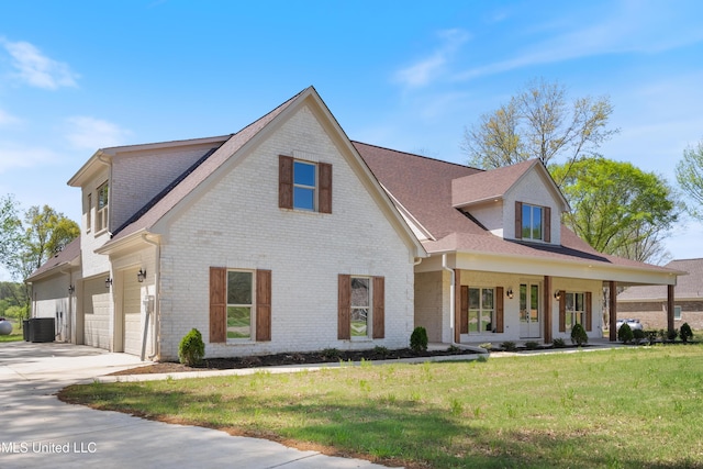 13721 Pebble Ridge Dr, Byhalia, MS 38611 - view of front facade with brick siding, central AC unit, driveway, a front lawn, and a porch