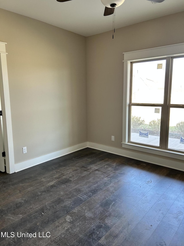 spare room with baseboards, plenty of natural light, ceiling fan, and dark wood-style flooring