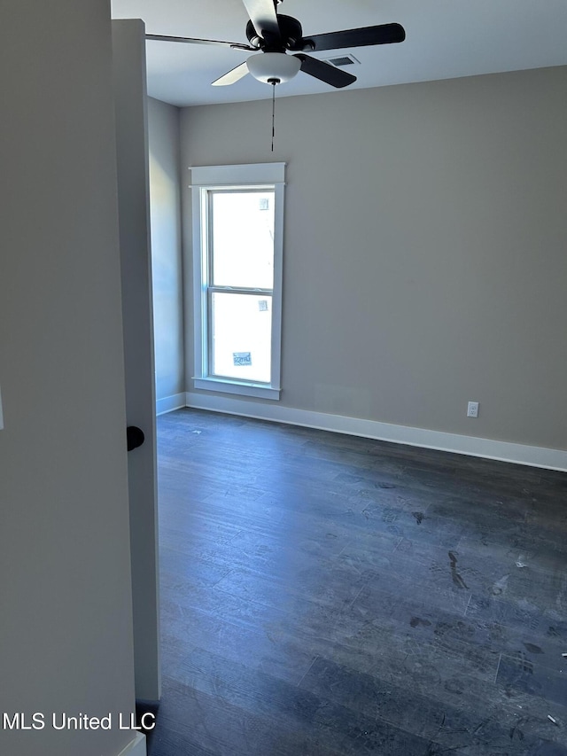 spare room with baseboards, wood finished floors, and a ceiling fan