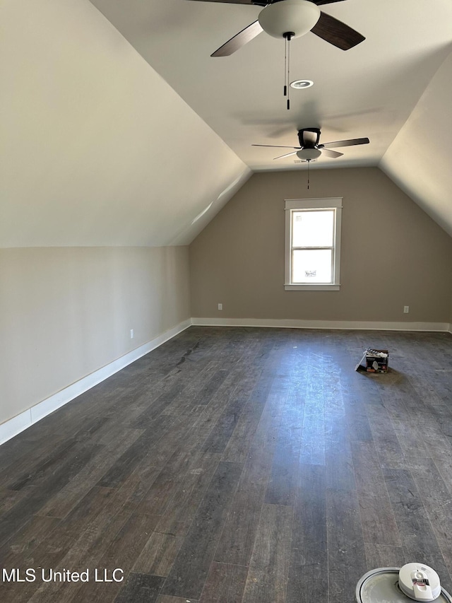 additional living space featuring vaulted ceiling, baseboards, and dark wood-style flooring