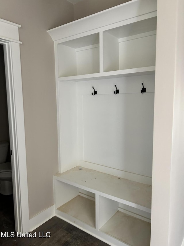 mudroom featuring dark wood-type flooring and baseboards