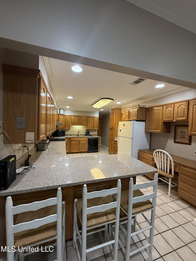 518 Main St, Natchez, MS 39120 - kitchen with freestanding refrigerator, a peninsula, a sink, recessed lighting, and light stone countertops