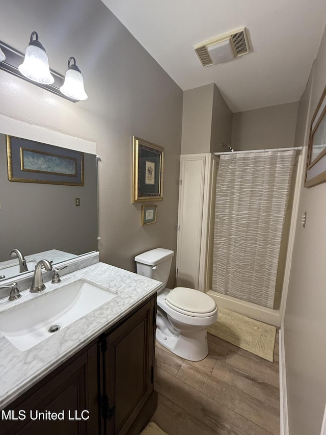 518 Main St, Natchez, MS 39120 - full bathroom with wood finished floors, toilet, vanity, and curtained shower