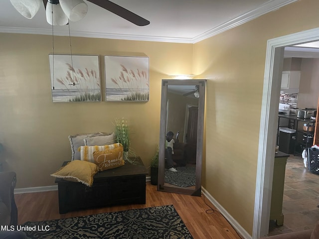 living area featuring ornamental molding, wood-type flooring, and ceiling fan