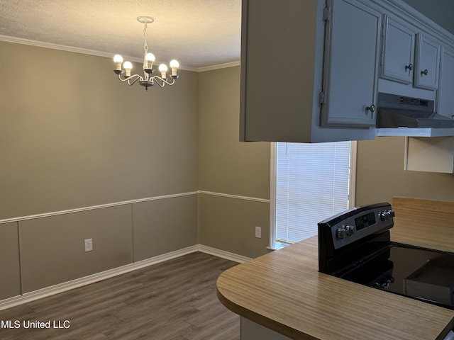 kitchen with pendant lighting, dark hardwood / wood-style floors, a notable chandelier, crown molding, and black electric range