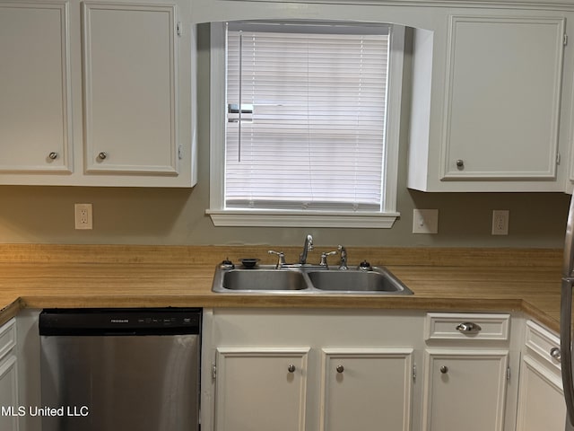 kitchen featuring stainless steel dishwasher, white cabinetry, and sink