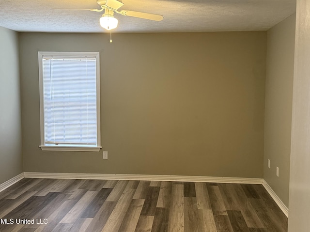 unfurnished room featuring a textured ceiling, ceiling fan, plenty of natural light, and dark wood-type flooring