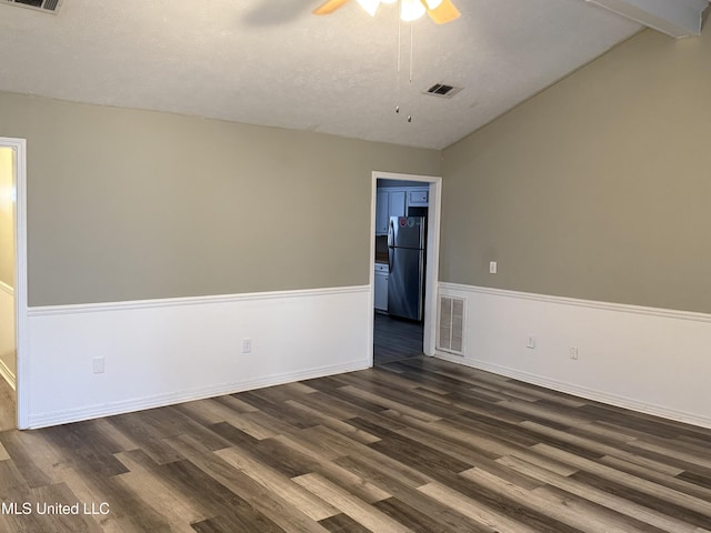 spare room featuring ceiling fan, vaulted ceiling with beams, and dark hardwood / wood-style floors