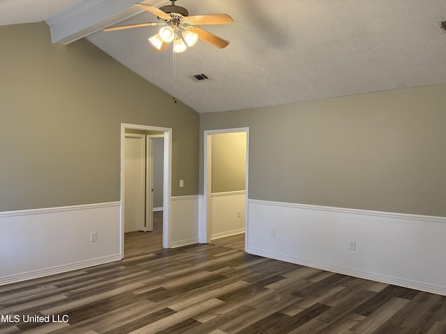 spare room featuring ceiling fan, dark hardwood / wood-style flooring, vaulted ceiling with beams, and a textured ceiling