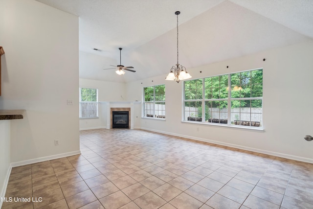 unfurnished living room with vaulted ceiling, tile patterned flooring, a tile fireplace, a chandelier, and a ceiling fan