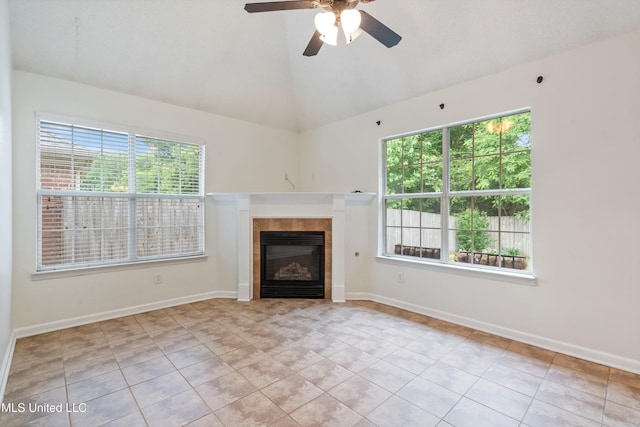unfurnished living room with plenty of natural light, tile patterned floors, lofted ceiling, a fireplace, and a ceiling fan