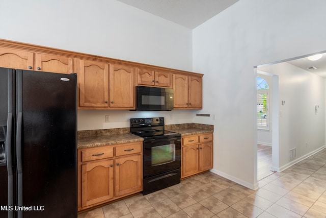 kitchen featuring black appliances, a high ceiling, dark countertops, light tile patterned flooring, and brown cabinetry