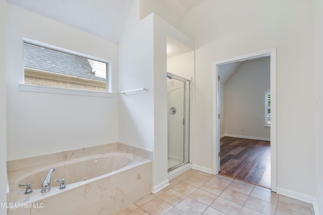 bathroom with a shower stall, tile patterned flooring, a garden tub, and vaulted ceiling