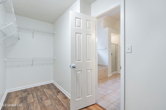 walk in closet with wood finished floors