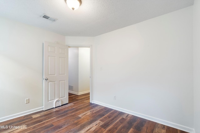 unfurnished room featuring baseboards and dark wood-style floors